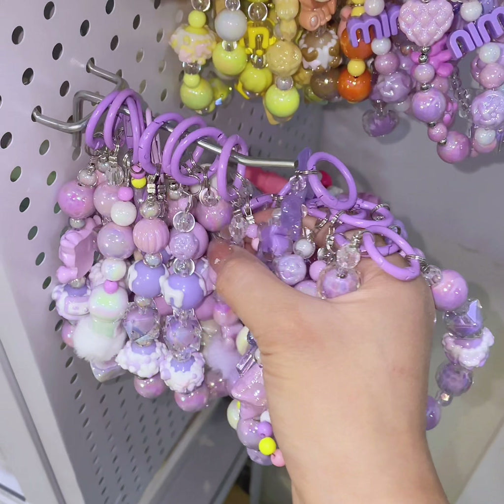Pastel bead keychains hanging on the board, ready to be scooped