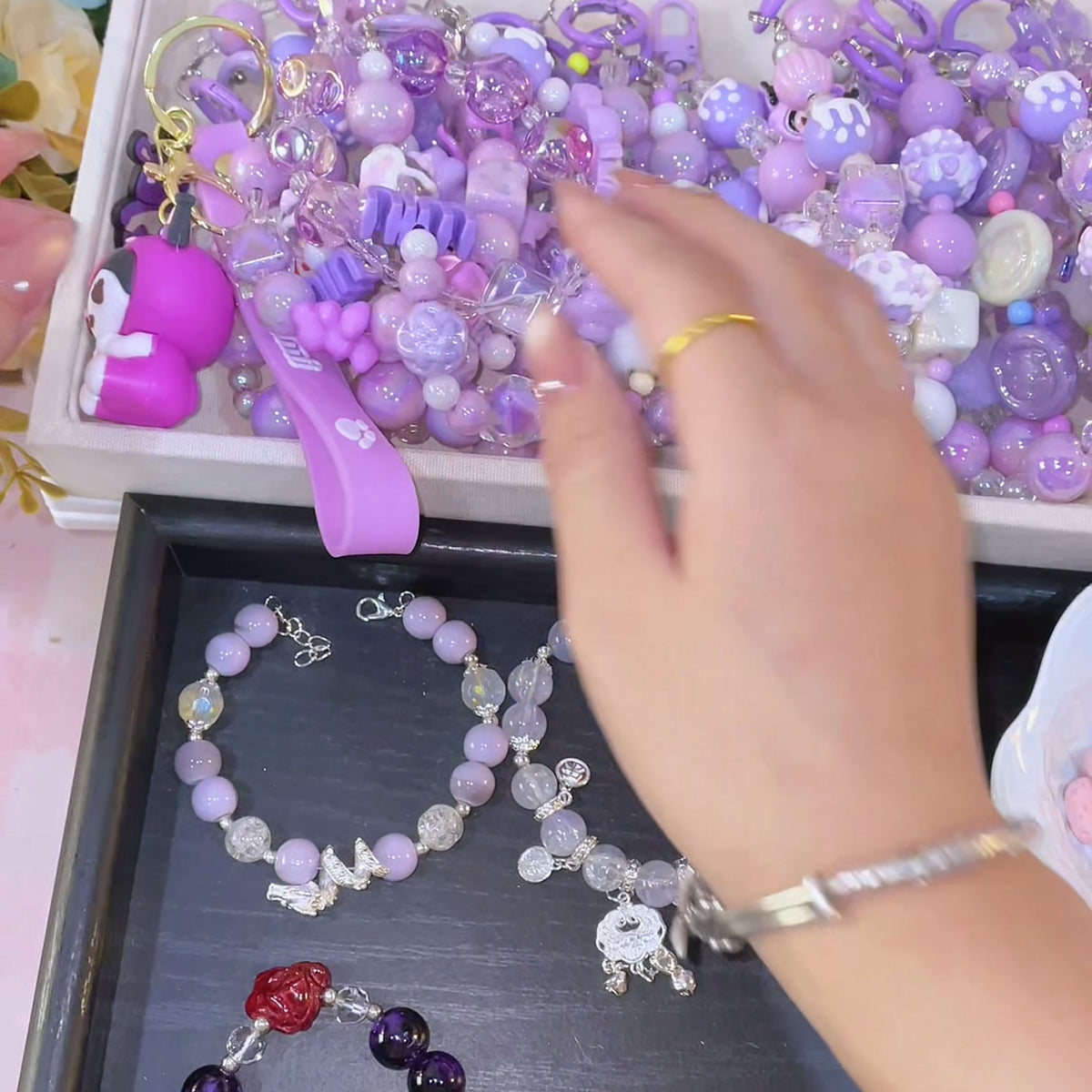 A tray full of purple charms and keychains